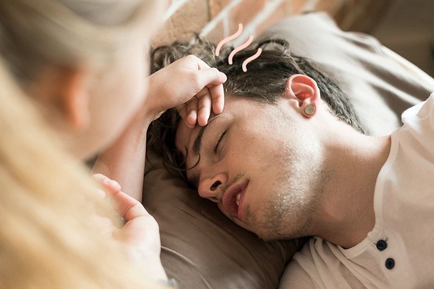 Kvinde rører på mands pande. Manden har influenza.